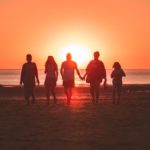 Family walking together on a beach at sunset